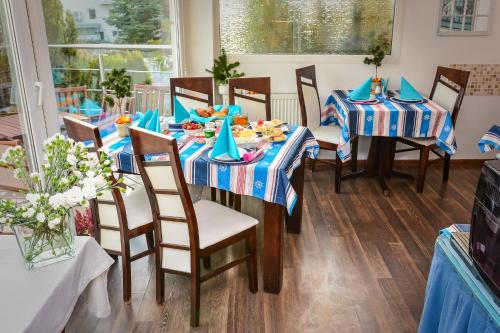 a dining room with blue and white tablecloths and chairs at Willa Bryza in Gdynia