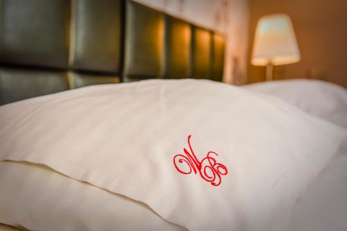 a white pillow with a red symbol on it at Willa Bryza in Gdynia
