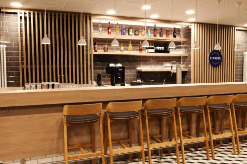 a bar with a row of stools in a restaurant at Holiday Inn Express - Mülheim - Ruhr by IHG in Mülheim an der Ruhr