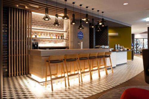 a bar in a restaurant with stools at Holiday Inn Express - Mülheim - Ruhr by IHG in Mülheim an der Ruhr