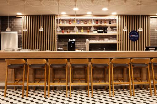 a row of stools at a bar in a restaurant at Holiday Inn Express - Mülheim - Ruhr by IHG in Mülheim an der Ruhr