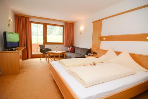 a hotel room with a large bed and a television at Hotel Sabine in Galtür