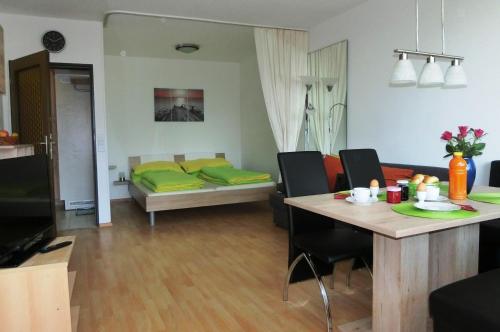 a living room with a bed and a table and chairs at RUTH Haus KMB Seeblickappartement direkt am Ossiacher See mit Hallenbad Skiarena Gerlitzen in Bodensdorf