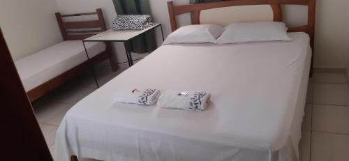 uma cama com duas almofadas num quarto em Pousada Rio Novo Jalapão em Mateiros