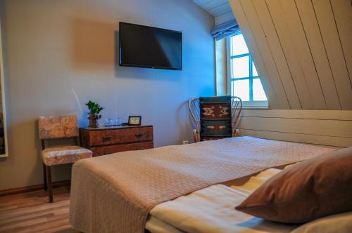 a bedroom with a bed and a tv on the wall at Maatilamatkailu Ali-Ketola in Kokemäki