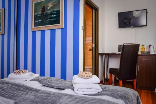 a bedroom with a bed with towels on it at Willa Bryza in Gdynia