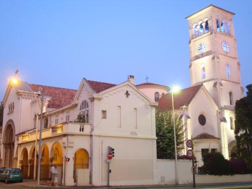 una iglesia con una torre de reloj en una calle en Trianon Palace, en Cannes