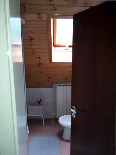 a bathroom with a toilet and a window at Apartments Rozi in Bovec