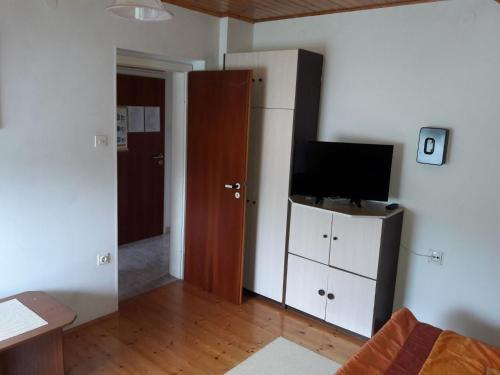 una sala de estar con TV en un armario blanco en Apartments Rozi, en Bovec