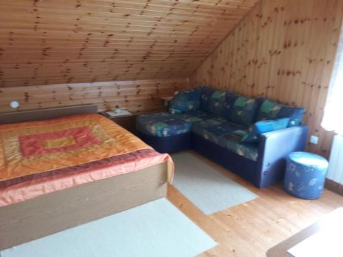 Habitación con sofá y cama en una cabaña en Apartments Rozi, en Bovec