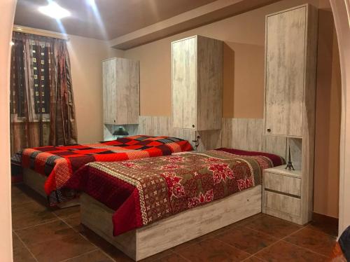 - une chambre avec 2 lits et des couettes rouges dans l'établissement Golden House, à Tbilissi