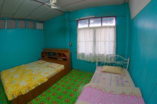 Posteľ alebo postele v izbe v ubytovaní บ้านสีฟ้า ณ.เชียงคาน