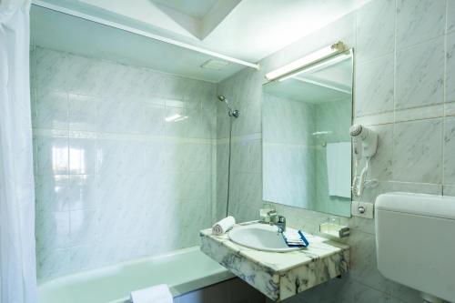 a white bathroom with a sink and a mirror at BelleVue Aquarius in Puerto del Carmen