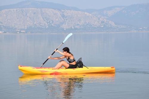 a woman is sitting on a kayak on a lake at Villa Aggemari in Apidias Lakos