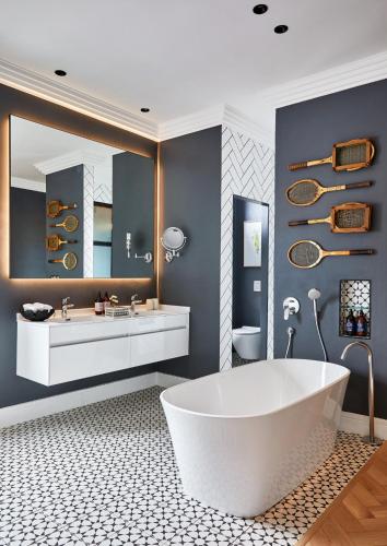 a bathroom with a large white tub and a mirror at Pineapple House Boutique Hotel in Cape Town