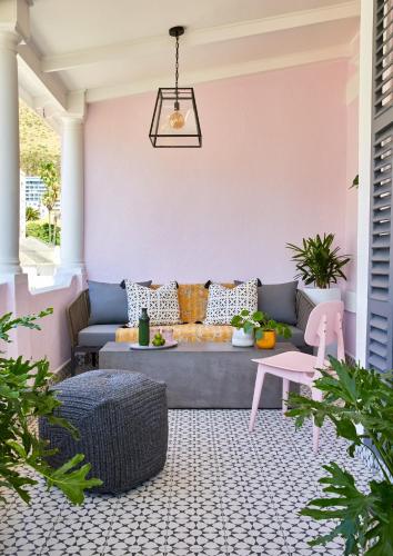 a patio with a couch and a pink wall at Pineapple House Boutique Hotel in Cape Town