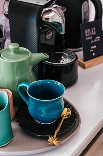 a blue cup on a plate next to a tea kettle at Pineapple House Boutique Hotel in Cape Town