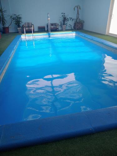 a swimming pool with blue water in a house at Quintana Hotel in San Luis