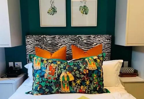 a bedroom with a bed with orange pillows and a green wall at Pineapple House Boutique Hotel in Cape Town