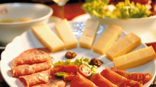a plate of food with cheese and other foods at Borgo Romantico Green Relais in Cavaion Veronese
