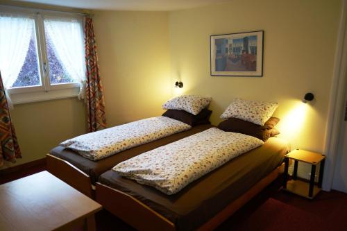 a bedroom with two beds in front of a window at ARNOLDS Bed & Breakfast in Interlaken