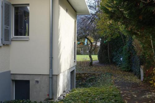 a side of a white building with a window at ARNOLDS Bed & Breakfast in Interlaken