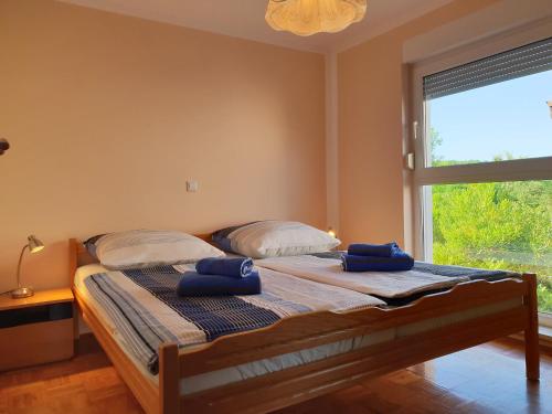 sypialnia z łóżkiem z dwoma niebieskimi ręcznikami w obiekcie Apartments Vodopija w mieście Soline