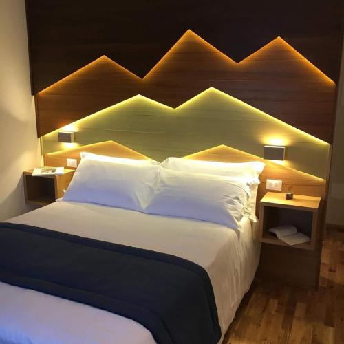 1 dormitorio con 1 cama grande y cabecero de madera en Hotel Miramonti, en Castel del Monte