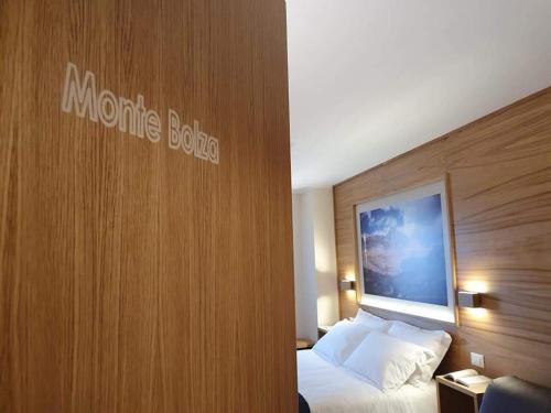 Habitación de hotel con cama y pared de madera en Hotel Miramonti en Castel del Monte