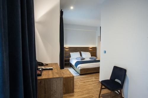 a bedroom with a bed and a desk and a chair at Trikala River House in Tríkala