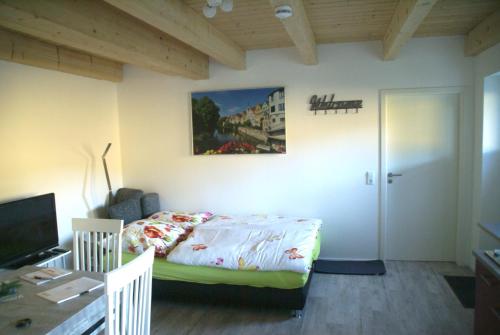 um pequeno quarto com uma cama e uma secretária em Heid-Blick em Gomadingen