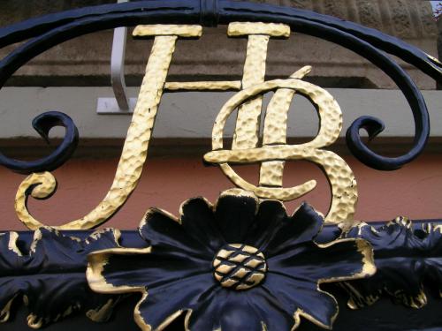 a large metal sign with a flower on it at Hôtel Restaurant Le Bristol in Niederbronn-les-Bains