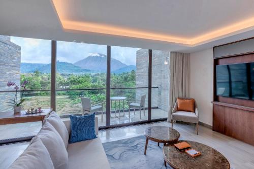 a living room with a couch and a large window at Gran Melia Arusha in Arusha