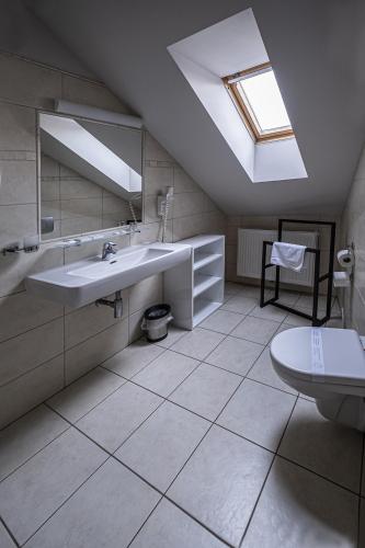 a bathroom with a sink and a skylight at Hotel Mario in Lednice