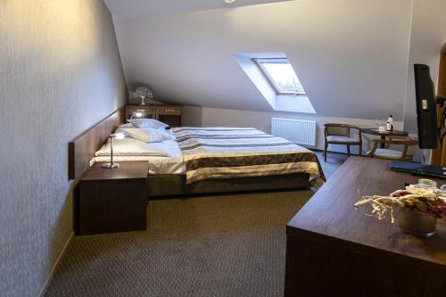 a bedroom with a bed and a table and a window at Hotel Mario in Lednice
