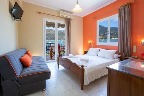 - une chambre avec un lit, un canapé et une chaise dans l'établissement Kerasoula Apartments, à Yénion