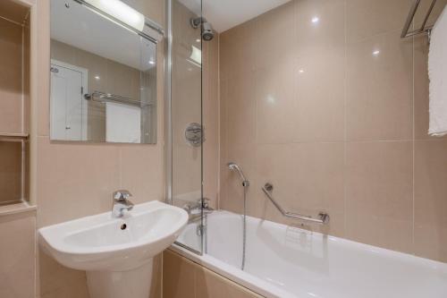 a bathroom with a sink and a shower and a tub at Quality Hotel Hampstead in London