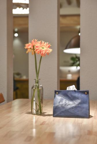 a vase with flowers in it sitting on a table at Shang Shan ruo shui 大理上山若水客栈 in Dali