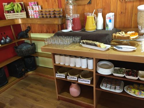 una cocina con una estantería con tazas y platos en Hotel Encanto del Río, en Valdivia