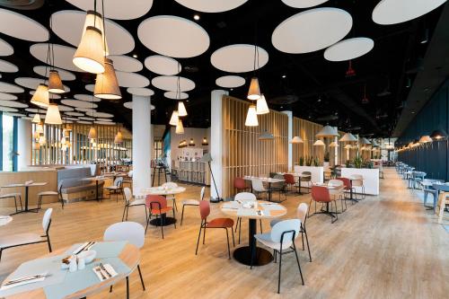 restauracja ze stołami, krzesłami i światłami w obiekcie APARTLUX Seaside Park - bezpośredni widok na morze w Kołobrzegu