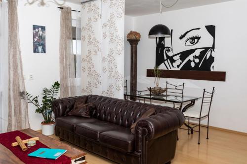 プラハにあるRichie Apartment near Aquaparkのリビングルーム(茶色の革張りのソファ、テーブル付)