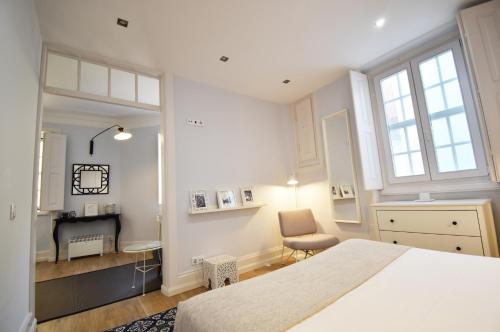 a bedroom with a white bed and white walls at Sophia Residences in Coimbra