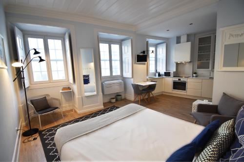 ein Wohnzimmer mit einem Bett und eine Küche in der Unterkunft Sophia Residences in Coimbra