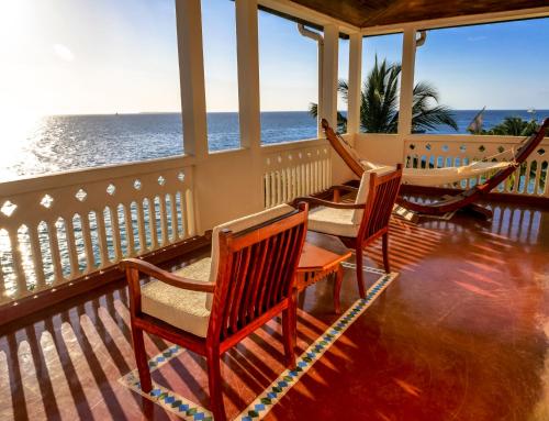 a porch with chairs and a hammock on the ocean at Zanzibar Serena Hotel in Zanzibar City