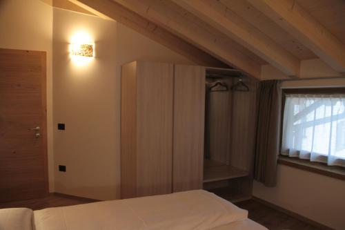 a bedroom with a bed and a window at MOUNTAIN RESORT Appartamenti in Commezzadura