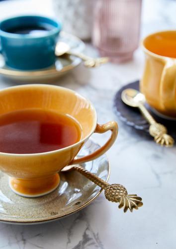 a cup of tea on a plate on a table at Pineapple House Boutique Hotel in Cape Town