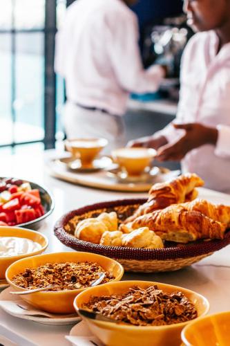 a table with many plates of food on it at Pineapple House Boutique Hotel in Cape Town
