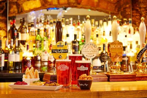 a bar with a bunch of bottles of alcohol at The Deddington Arms in Banbury