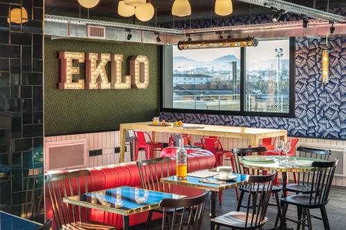 a restaurant with tables and chairs and a bar at Eklo Clermont Ferrand Centre Gare in Clermont-Ferrand