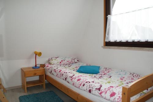 um pequeno quarto com uma cama e uma janela em Ferienhaus Breithaupt em Cuxhaven